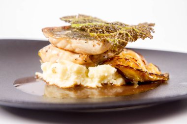 Mersin balığı, savoy lahana, mantar suyu, beyaz bir arka plan üzerinde bir tabakta tereyağlı patates püresi