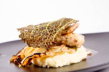 Mersin balığı, savoy lahana, mantar suyu, beyaz bir arka plan üzerinde bir tabakta tereyağlı patates püresi