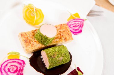 Kızarmış domuz eti bonfile gevrek patates ekmek, Marine beetroots ve yeşil biber sosu ile bir restoranda servis