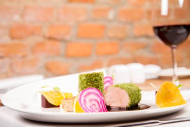 Kızarmış domuz eti bonfile gevrek patates ekmek, Marine beetroots ve yeşil biber sosu ile bir restoranda servis