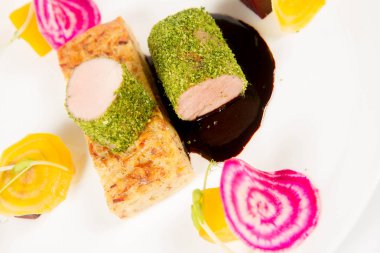 Beyaz zemin üzerinde bir plaka üzerinde Marine beetroots ve yeşil biber soslu domuz eti bonfile gevrek patates ekmek ile kızartma