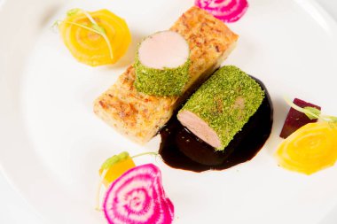 Beyaz zemin üzerinde bir plaka üzerinde Marine beetroots ve yeşil biber soslu domuz eti bonfile gevrek patates ekmek ile kızartma