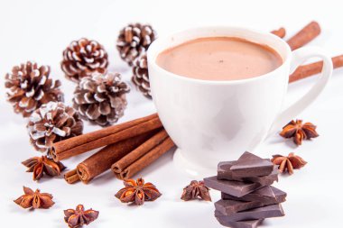Bir fincan tarçınlı sıcak çikolata, anason yıldızları, siyah çikolata parçaları ve biraz koni.