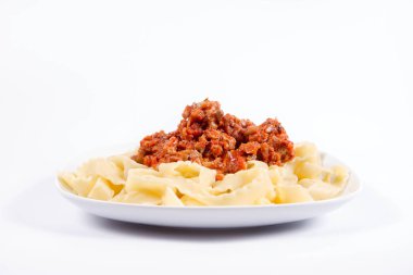 Beyaz arka planda bir tabakta bolonez soslu reginette makarna.