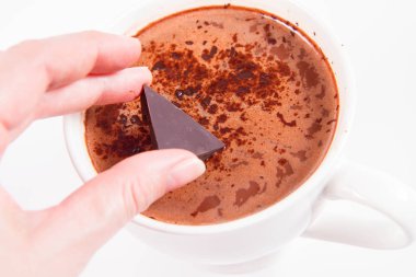 Bir bardak sıcak çikolata ve içine bir parça çikolata koy.