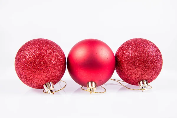白色背景下的红床垫和闪闪发光的圣诞球 — 图库照片