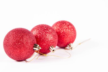 Beyaz arka planda kırmızı parıldayan noel topları