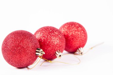 Beyaz arka planda kırmızı parıldayan noel topları