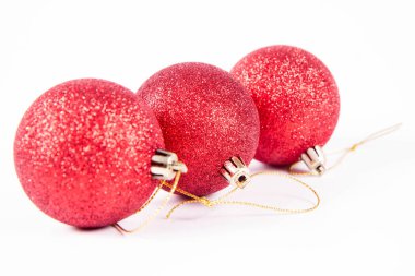 Beyaz arka planda kırmızı parıldayan noel topları