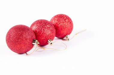 Beyaz arka planda kırmızı parıldayan noel topları
