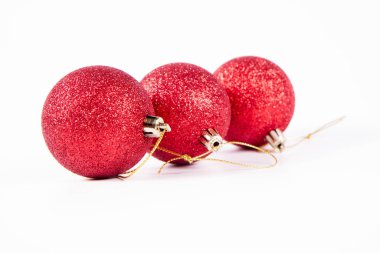 Beyaz arka planda kırmızı parıldayan noel topları