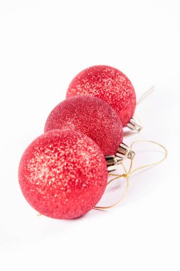 Beyaz arka planda kırmızı parıldayan noel topları