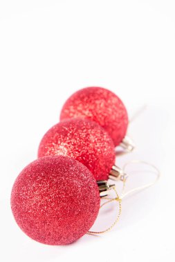 Beyaz arka planda kırmızı parıldayan noel topları