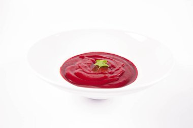 Kişniş yaprağıyla süslenmiş pancar kremalı çorba.