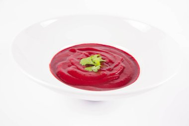 Kişniş yaprağıyla süslenmiş pancar kremalı çorba.