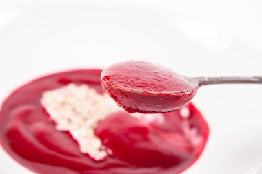 Yoğurttan yapılmış bir kalple süslenmiş pancar kremalı çorba ve ayçiçeği tohumları eski bir kaşıkla yenir.