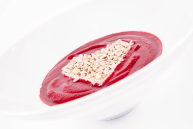 Yoğurt ve ayçekirdeğinden yapılmış bir kalple süslenmiş pancar kremalı çorba.