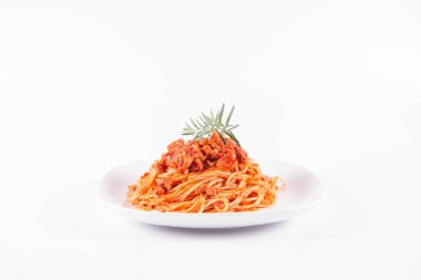 Biberiye dalıyla süslenmiş bir tabakta spagetti bolonez.