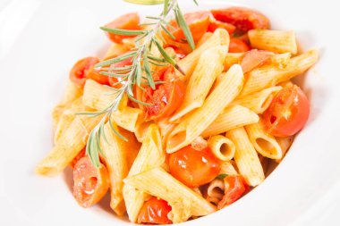 Domatesli makarna, sarımsak ve biberiye dalıyla süslenmiş mozzarella, beyaz arka planda.