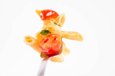 Beyaz arkaplanda çatallı domatesli, sarımsaklı ve mozarellalı makarna.