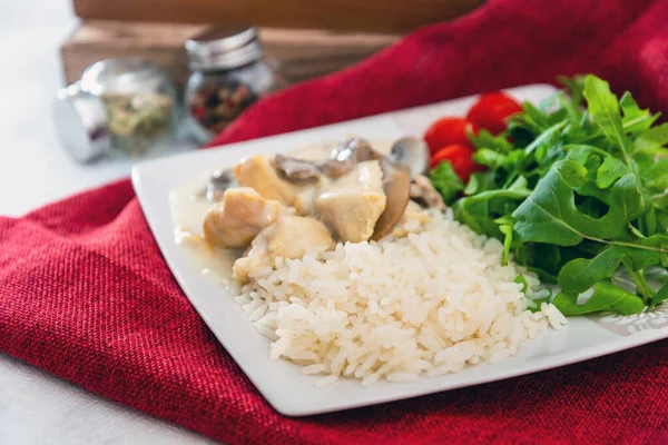 Pieces of chicken fillet cooked in a cream sauce with mushrooms and lemon juice, served with rice.