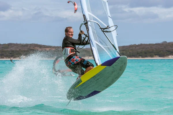 ターコイズ ブルーのラグーンにジャンプ Kitesurfer — ストック写真