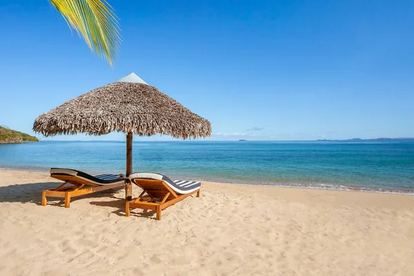 Two sunbeds under a straw umbrella — Stock Photo, Image