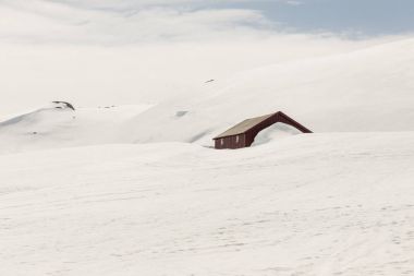 Wooden cottage under snow - Norway. clipart