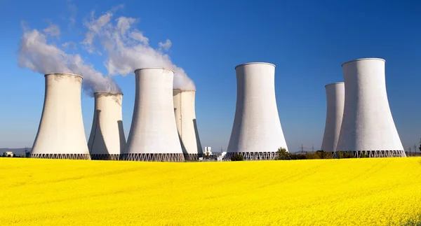 Central nuclear, torre de enfriamiento, campo de colza — Foto de Stock