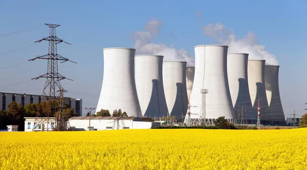 Centrale nucléaire, tour de refroidissement, champ de colza Images De Stock Libres De Droits