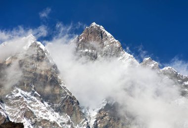 Lhotse üst bulutlar üstünde belgili tanımlık tepe ile