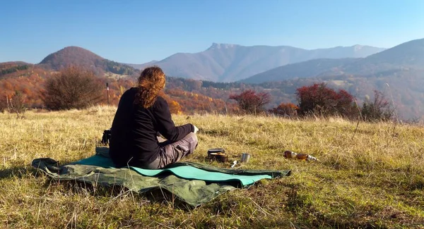 Hombre sentado en el prado y vista otoñal del monte Klak — Foto de Stock