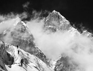 Bulutlar üstünde belgili tanımlık tepe ile Lhotse Dağı