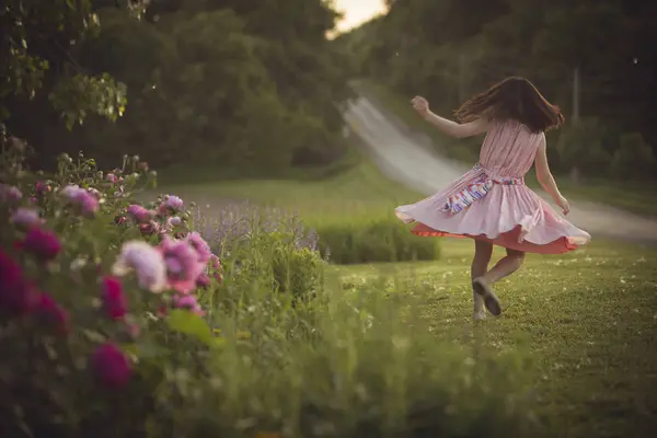 Yeşil çimenlerin üzerinde dans elbiseli kız — Stok fotoğraf