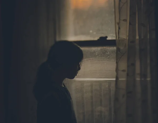 Дівчина-підліток стоїть біля вікна — стокове фото