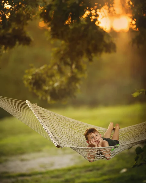 Красивый маленький мальчик лежит в гамаке — стоковое фото