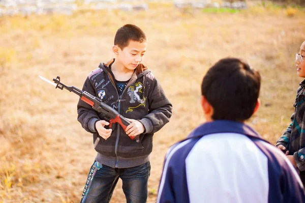 Китайские дети играют с игрушечными пушками — стоковое фото