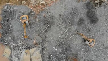 Aerial overhead moving downward view of a demolition site with two excavators