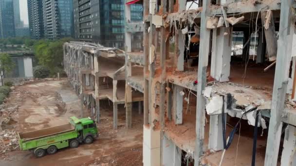 Aerial moving upward view of a demolition site with a green truck in China — Stock Video