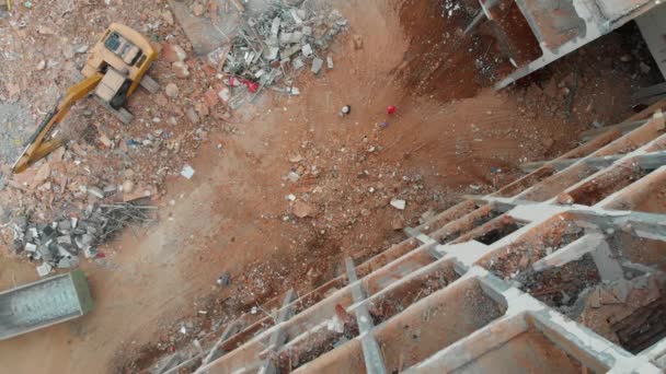 Vista aérea de arriba hacia abajo de un sitio de demolición con excavadora — Vídeos de Stock