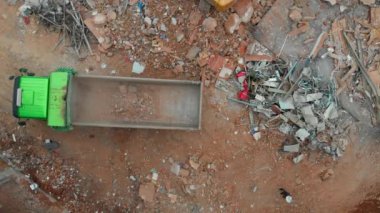 Kazıcı ve kamyonla birlikte bir yıkım alanının havadan yukarıdan görüntüsü