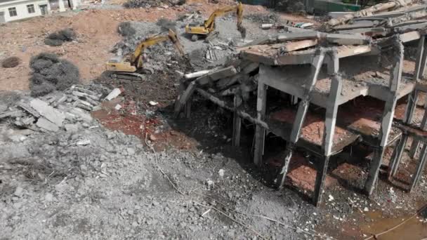 Vista aérea de arriba hacia adelante de un sitio de demolición con dos excavadoras — Vídeos de Stock