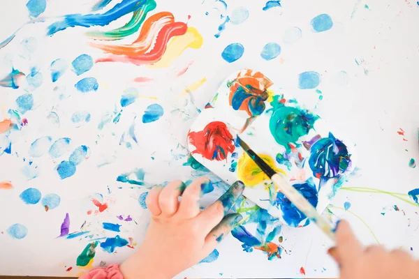 A child is painting with fingers and brush and oil paints — Stock Photo, Image