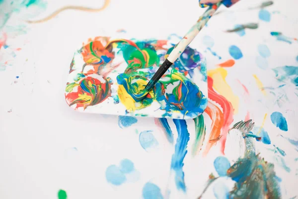 Un bambino sta dipingendo con le dita e pennello e vernici ad olio — Foto Stock