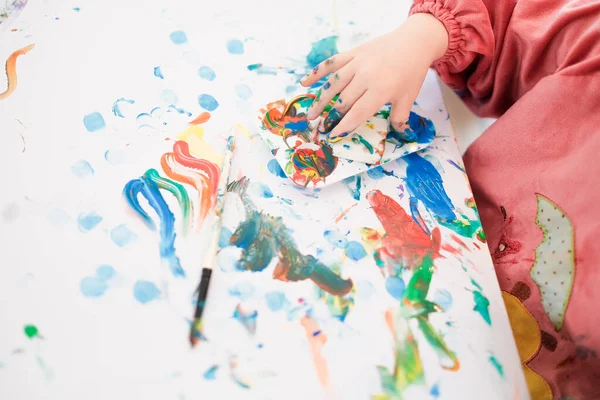 Et barn maler med fingre og børste og olie maling - Stock-foto