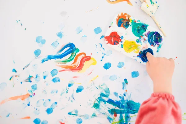 Un bambino sta dipingendo con le dita e pennello e vernici ad olio — Foto Stock
