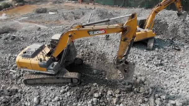 Aerial overhead moving around view of a demolition site with two excavators — Stock Video