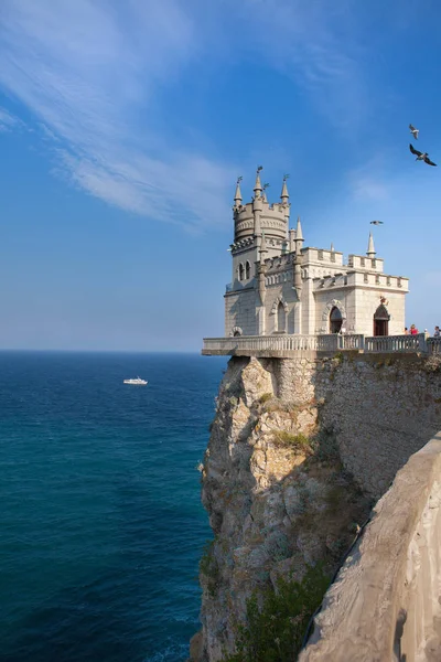 Bir görünümü deniz ve zevk tekneler seyir kayalar, arka plan üzerine bir uçurumun üzerinde inşa sarayın romantik yutmak yuva. Crimea