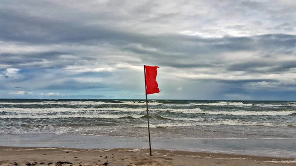 浜辺の赤い旗 ストック画像