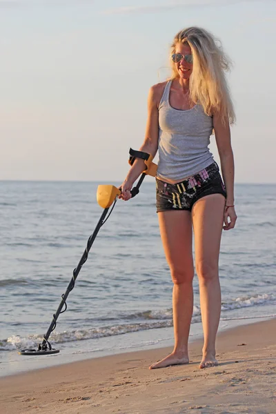 Metal dedektörü ile güneş gözlüklü sarışın kız — Stok fotoğraf